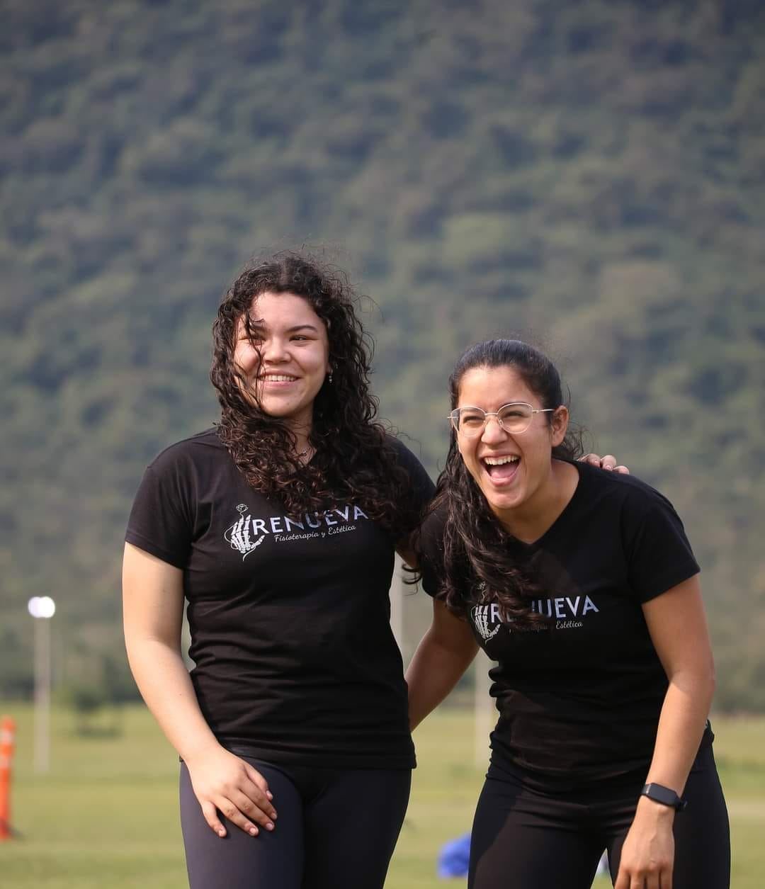 María Flores y Belén Rodas, las fisioterapeutas de Renueva, riéndose al aire libre con sus remeras de la clínica